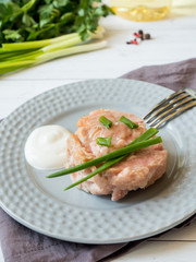 Canned tuna in its own juice with green onions on a plate. selective focus