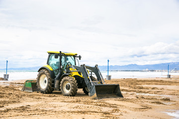 Tractor clean beach on coastline Costa Dorada, Salou, Spain.