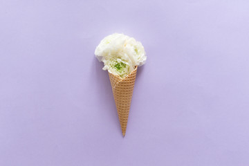 View from above of waffle cone with flower composition on lilac background with copy space, flat lay