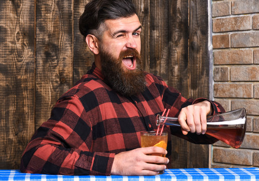Cheerful bartender concept. Bartender pouring glass and blinking.
