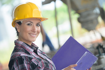 Portrait of woman wearing hardhat and holding a folder