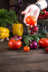 Onions, peppers, dill, tomatoes, cucumbers, radishes, dill, rucola and mushrooms on a wooden dark background