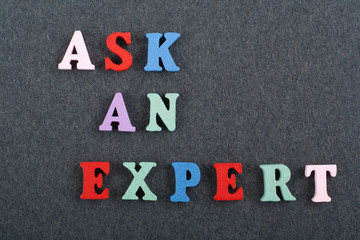 ASK AN EXPERT word on black board background composed from colorful abc alphabet block wooden letters, copy space for ad text. Learning english concept.