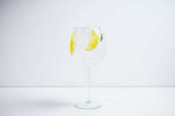 Gin with lemon slice and ice in wine glass. Selective focus.