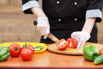 The cook cuts fresh farm vegetables