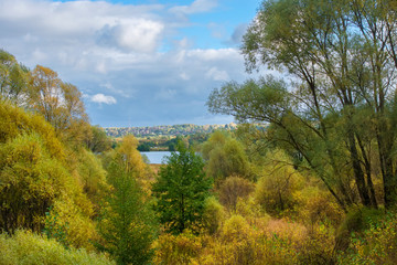 Autumn landscape. Autumn trees at the bank of the river in sunny autumn day