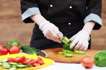 The cook cuts fresh farm vegetables