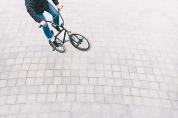 BMX freestyle on the square top view. A young man is doing tricks on a BMX bike. BMX culture