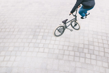 BMX racer makes complex tricks. Top view. The minimalist photo of a cyclist who does tricks on a...