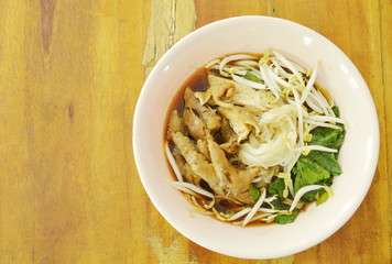 boiled thin rice noodles chicken leg and feet with bean sprout in herb brown soup on bowl
