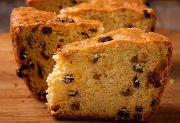 slices of home made cake with raisins on wooden plate close up