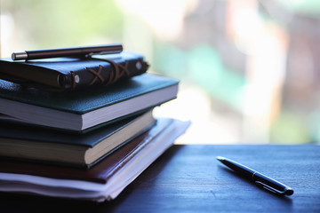 A stack of textbooks on the windowsill