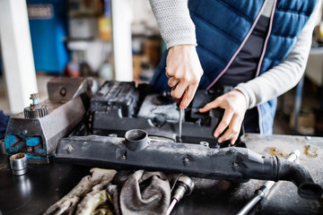 Obraz premium Man mechanic repairing a car in a garage.