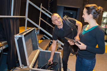 Man and woman packing away sound equipment