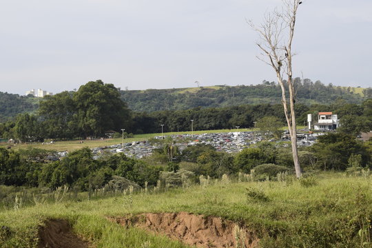 Horizonte de paisagem verdejante com dep&oacute;sito de sucatas de autom&oacute;veis