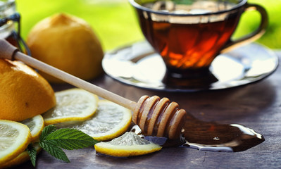 Tea with lemon and mint in nature. A cup of hot mint tea with le