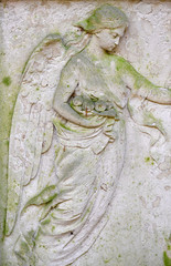 A weathered relief of an angel in front of a crypt of the cemetery in Berlin-Stahnsdorf