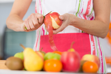 woman peeling apple in the kitchen