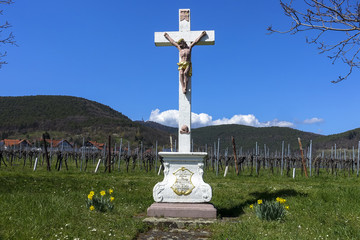 jesus cross in front of daffodils spring flowers and hambach castle in Sankt Martin, Palatinate,...