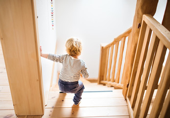 Toddler boy in dangerous situation at home. Child safety concept.