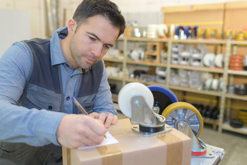 worker writing the client's address on a  paper