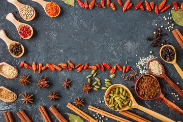 spices and herbs over black stone background