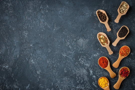 spices and herbs over black stone background. Flat lay