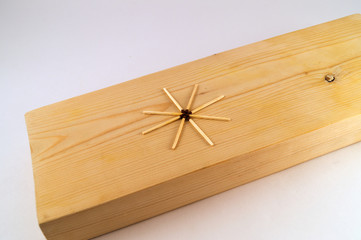 On the processed surface of the wooden board, there are several matches laid in the form of a star.
