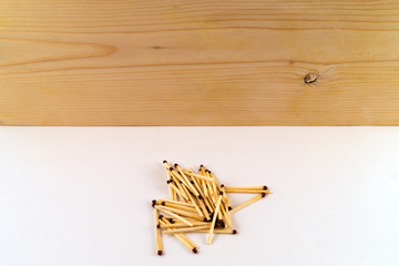Wooden texture at the top of the image, at the bottom - a few matches in an arbitrary shape on a...