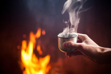 Keuken spatwand met foto Hand holding cup of hot tea by the fire © bdavid32