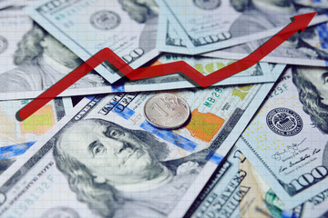 red arrow chart on the background of hundred-dollar bills and the Russian ruble. Exchange Rates. Growth of the dollar