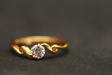 Diamond with gold ring on black floor