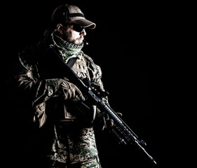 Naklejka premium Studio shot of United States Marine with rifle weapons in uniforms. Military equipment, army helmet, combat boots, tactical gloves. Isolated on black, weapons, army, patriotism concept