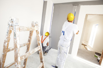 House painter paints a wall in a new home. Unrecognizable Person.