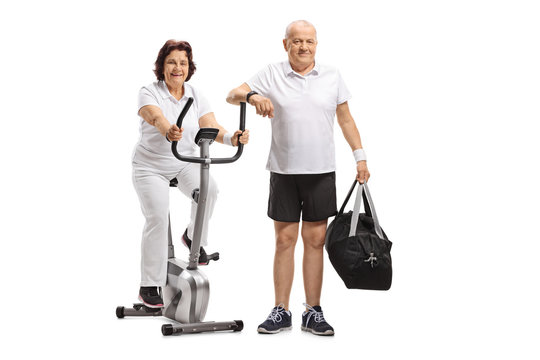 Mature woman on a stationary bike and a mature man with a sports bag