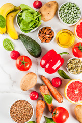 Healthy food background, trendy alkaline diet products - fruits, vegetables, cereals, nuts. oils, white marble background top view copy space