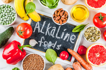 Healthy food background, trendy Alkaline diet products - fruits, vegetables, cereals, nuts. oils, white marble background above
