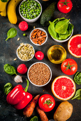 Healthy food background, trendy Alkaline diet products - fruits, vegetables, cereals, nuts. oils, dark blue concrete background above