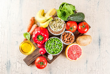 Healthy food background, trendy Alkaline diet products - fruits, vegetables, cereals, nuts. oils, light concrete background  copy space above