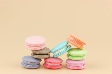 Sweet French macaroons cake (or macarons) with vintage pastel colored tone on orange background.