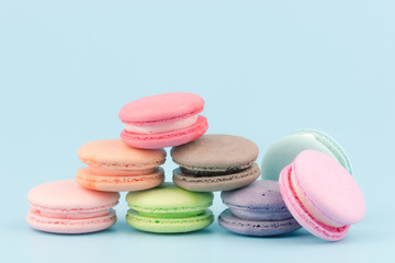 Fototapeta na wymiar Sweet French macaroons cake (or macarons) with vintage pastel colored tone on blue background.