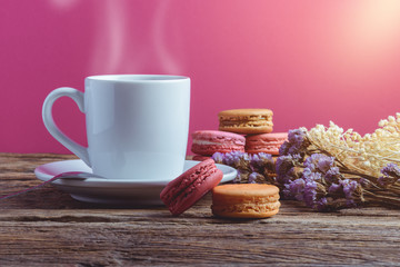 Different types color of macaroons with Cup of hot tea on Old grunge wooden background