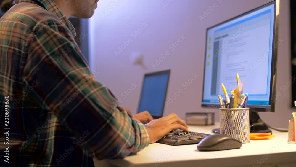Poster deadline, technology and people concept - programmer with computer working together late at night of