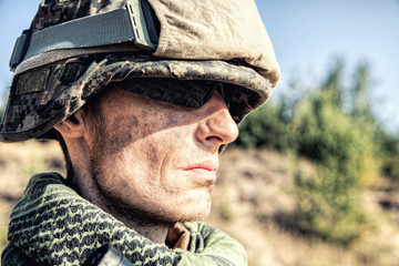 Location shot of United States Marine with rifle weapons in uniforms. Military equipment, army helmet, warpaint, smoked dirty face, tactical gloves. Weapons, army, patriotism concept