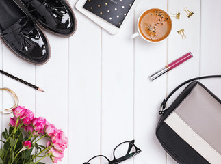 Feminine accessories with shoes, bag and coffee on the white table
