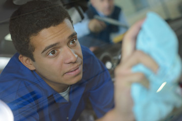 Young man cleaning window with cloth