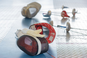 fencing mask and rapier on floor