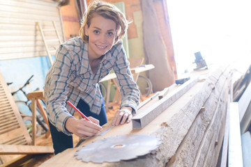 female carpenter using electric sander for wood