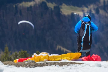 Fotobehang Luchtsport paraglider bereidt zich voor om in de bergen te beginnen