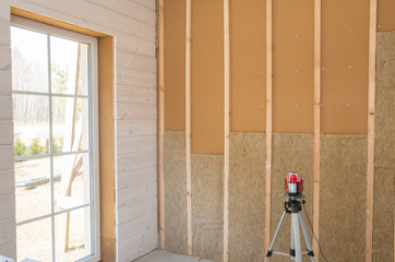 Construction worker thermally insulating eco-wood frame house with wood fiber plates and...